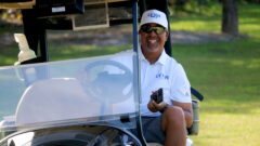 Coach Andy Walker is all smiles as he takes a ride in a golf cart