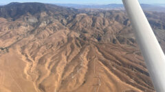 Aerial view of wind turbines and mountains departing California.