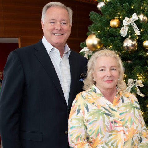 Kevin and Nancy Rickard pose in front of a christmas tree.