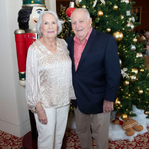 Caryn and Arthur Levison pose in front of a Christmas tree.