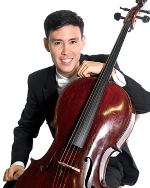 Akmal Irmatov '15, '18 poses with a smile, leaning on his cello.