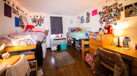 Frieburger Dorm Room with two twin beds, two desks with chairs, two dressers, and lots of student decorations.