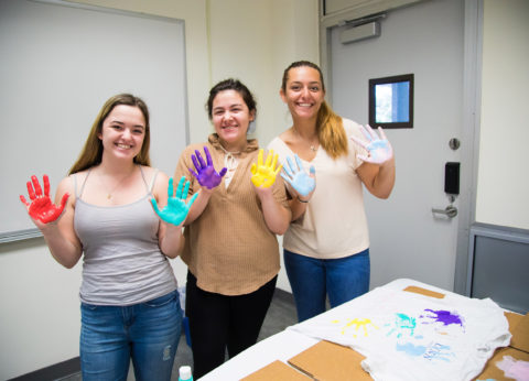Students paint with their hands at J-Term event.