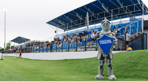 Lance the Fighting Knight bears his shield and sword in front of Bobby Campbell Stadium stands.