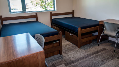 Perper Residence Hall bedroom with two full-size beds, two desks and two chairs.