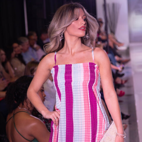 A woman walks down the runway at Lynn's fashion showcase.