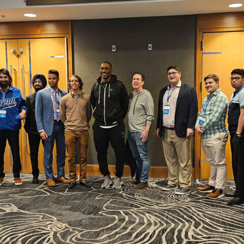 Eleven students from the College of Business and Management take a group picture inside halls of the NFL Combine event.