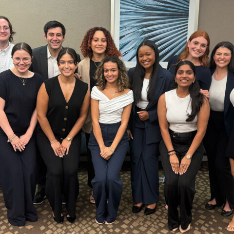 Regional first place winning students in professional attire pose together during the 2025 National Student Advertising Competition day.