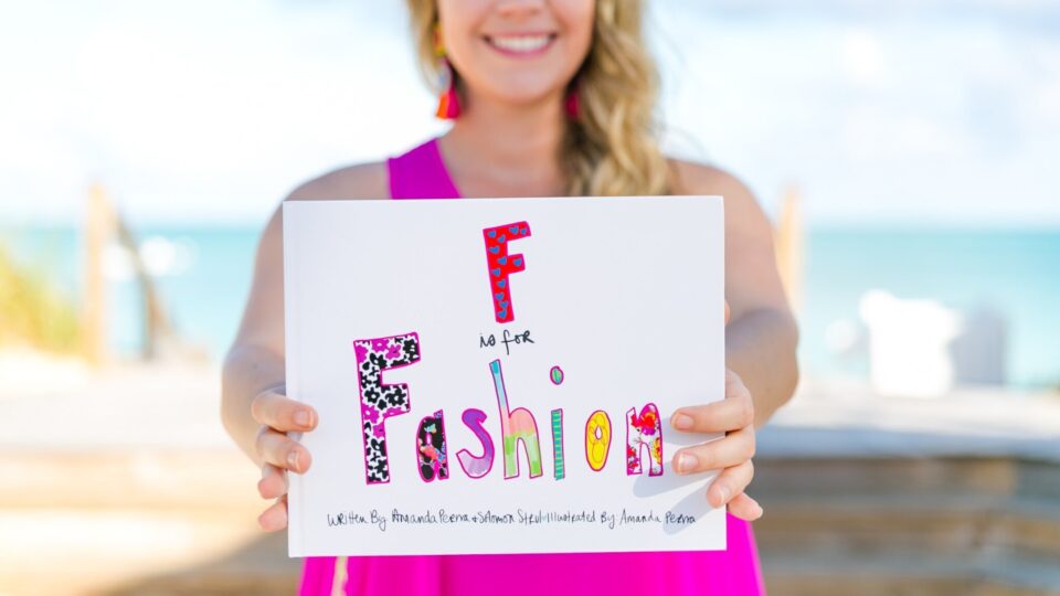 Amanda holds up the cover of her children’s book “F is for Fashion.”