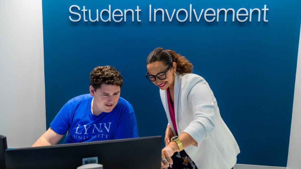 Lauren Harding helps a student on their computer.