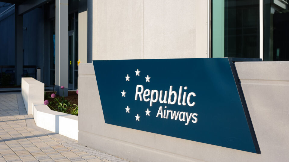The Republic Airways logo surrounded by 7 white stars in front of the headquarters building.