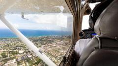 An aerial view of a Lynn airplane flying over the coast of South Florida.