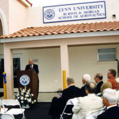 Historical photo of Dr. Donald Ross speaking in front of the Burton D. Morgan College of Aeronautics.
