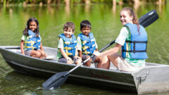 Three campers and a counselor enjoy a canoe ride at Pine Tree Camps.
