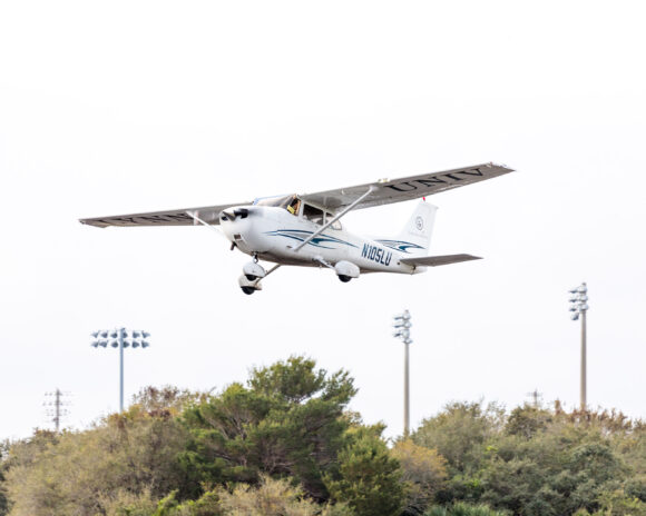 A Lynn plane passes overhead from the College of Aeronautics.
