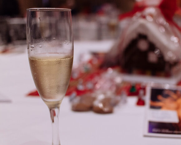 A glass of champagne sits on a table at the Gingerbread Concert.