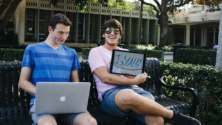 Two Lynn University students sit on a bench.