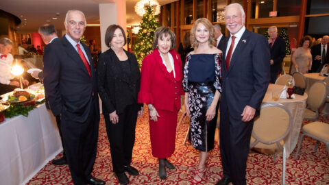 Attendees pose in the Wold Performing Arts Center at the President's Holiday Party.