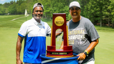 Athletic director Devin Crosby and Coach Andy Walker stand with the 2019 NCAA National Championship trophy