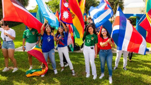 Students hoist flags for a group picture