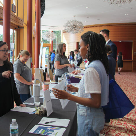 Student talks to employer at a career fair on Lynn University's campus.