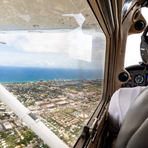An aerial view of a Lynn airplane flying over the coast of South Florida.