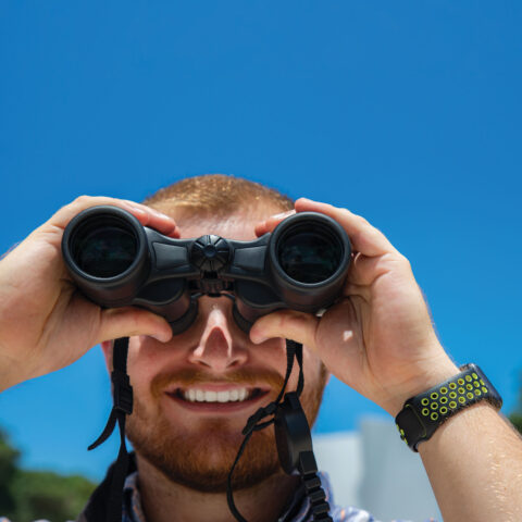 Student looks through a pair of binoculars