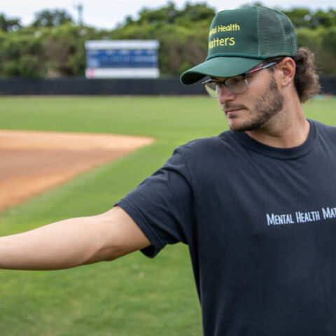 Drew Clark '23 poses with a baseball in Lynn University's baseball field.