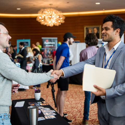 A student and a professional shake hands at Lynn's employment fair.
