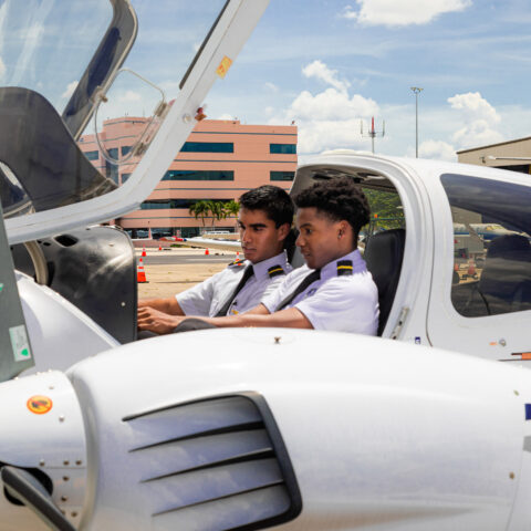 Students sit in an aircraft at the College of Aeronautics.