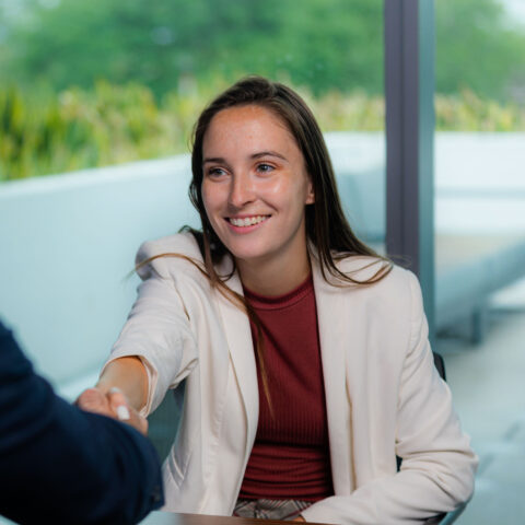 A student shakes the hand of a business owner.