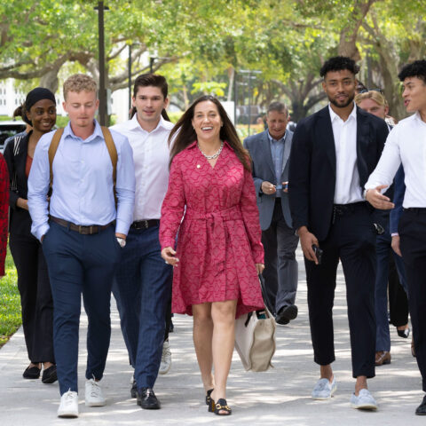 Jen Leary walks outside of Lynn's campus with a group of students.