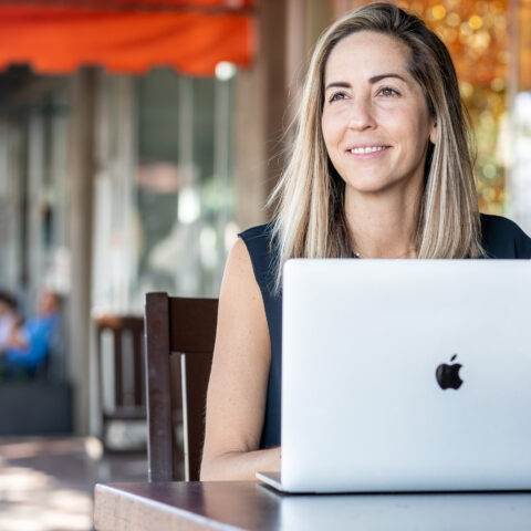 A graduate student works on her laptop at a cafe.