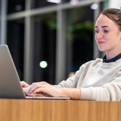 A student works on a laptop in the university center.