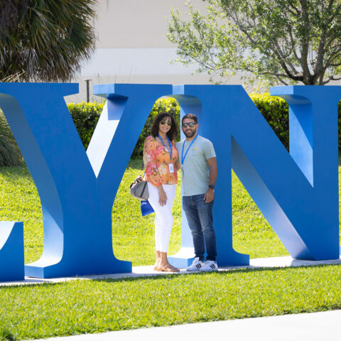 Lynn University alumni pose next to the LYNN letters in Christine's Park.