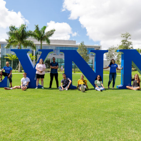 Students in front of the Lynn letters on the grass.