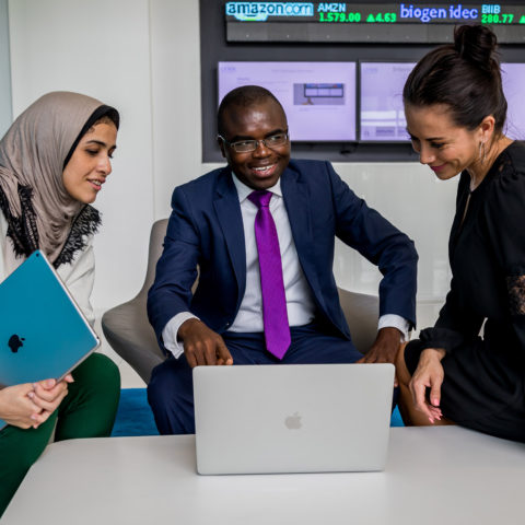 Diverse students work together in the IBC on a laptop.