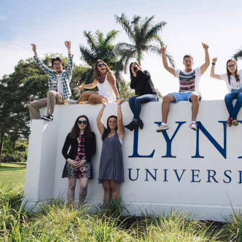 Students pose outside on Lynn University sign in Boca Raton.