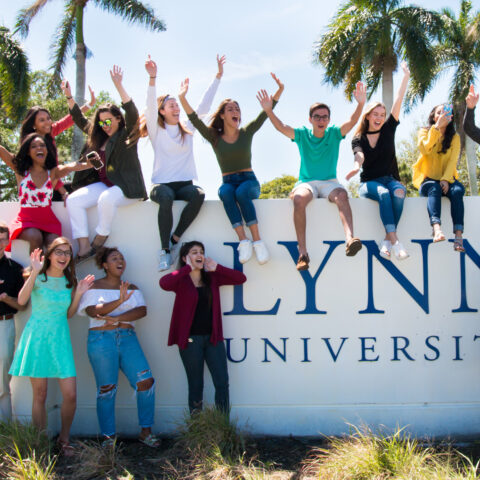Students celebrate on top of the Lynn University sign.