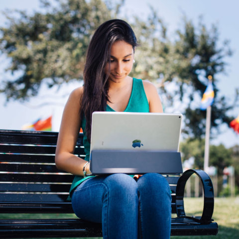 Undergraduate international student, Eloisa Sarmiento, uses her iPad Pro with keyboard outside.