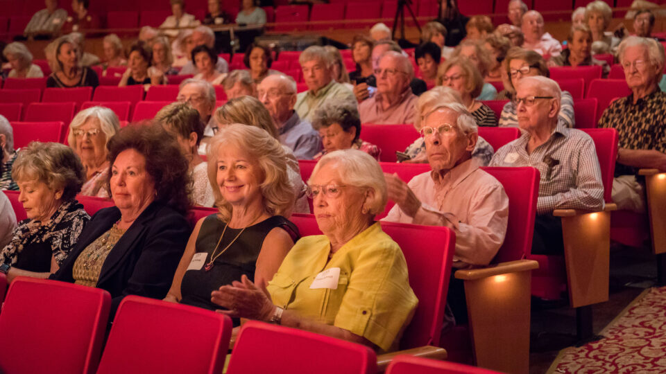 Friends of the Conservatory sit in a theater during a performance
