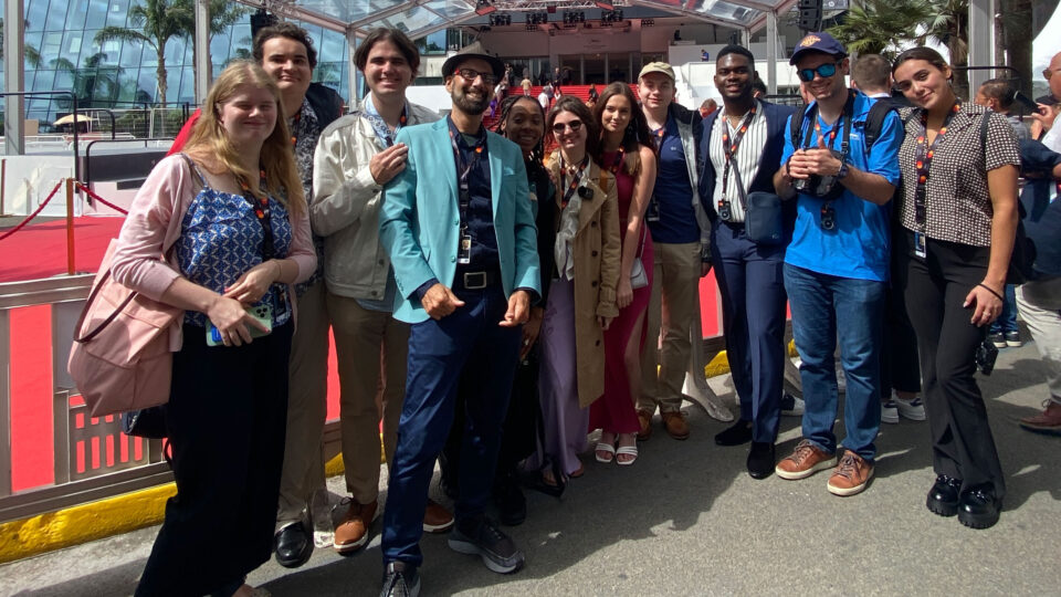 Ben Orifici and Lynn film students take a group picture in front of a red carpet event at Cannes.
