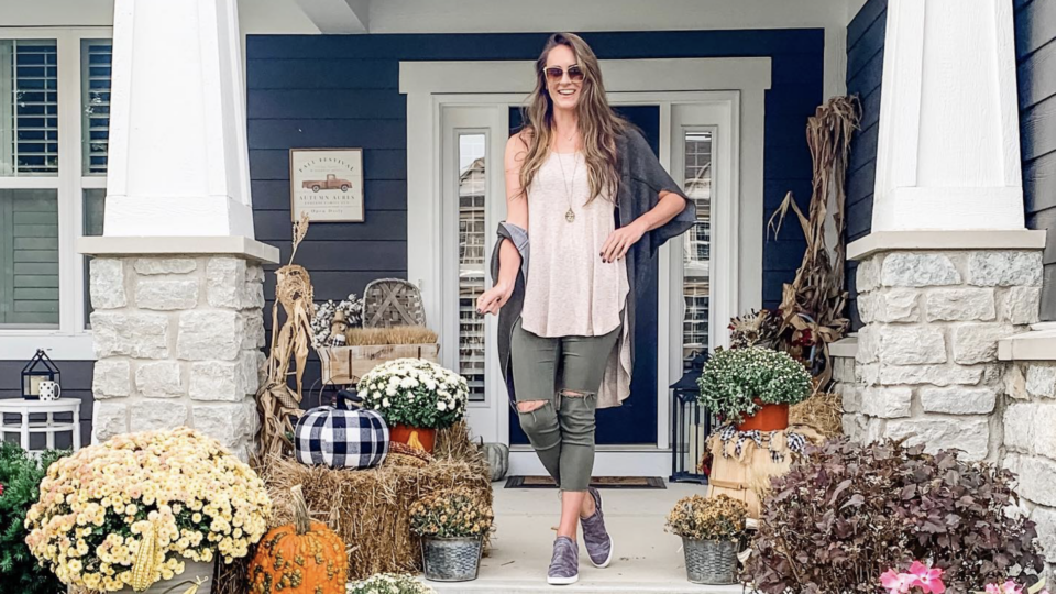 Haley poses outside of a house decorated for fall.