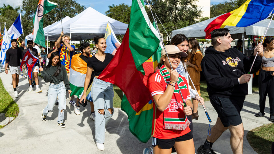Students march through Christine's Park holding up various flags from around the world.