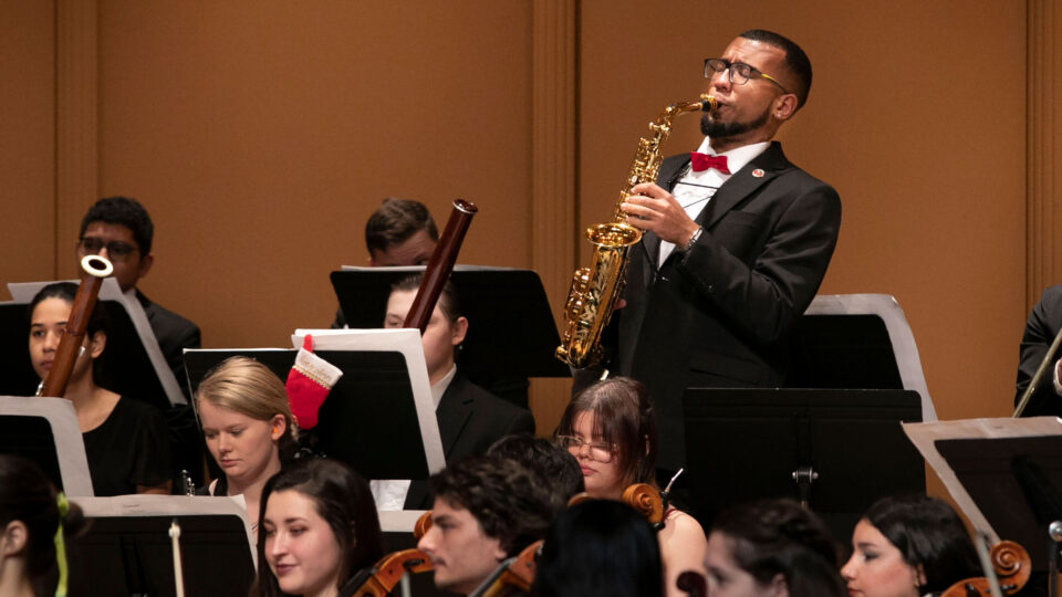 Lynn University conservatory student plays saxophone at holiday concert.