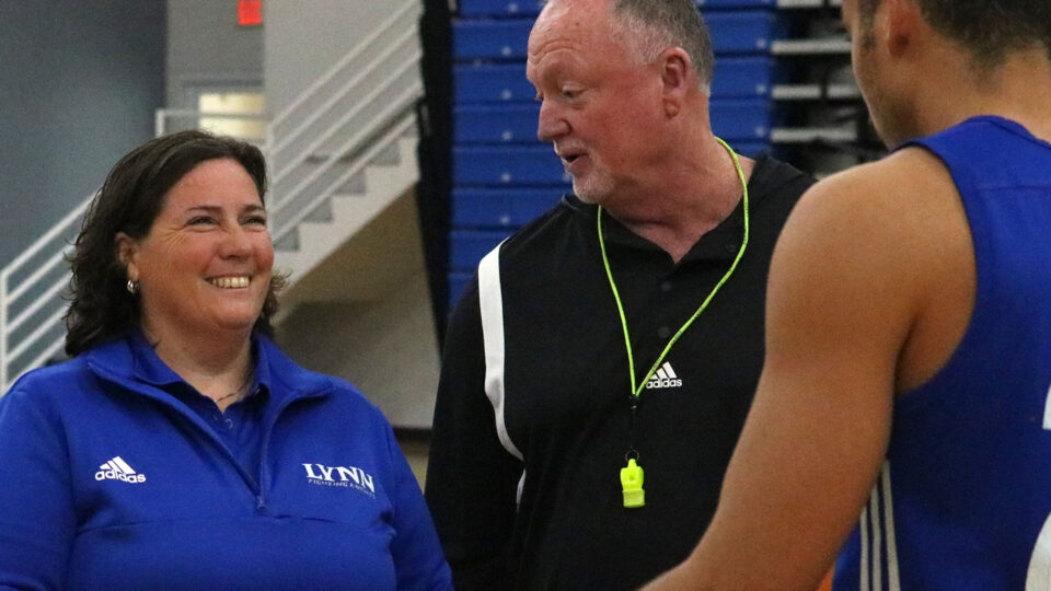 Kathy Kroupa, athletics director smiles as she faces a basketball student-athlete