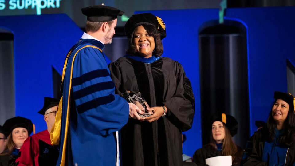 Audrey Gregory receives Lynn's 2023 Distinguished Alumni Award from President Ross during Commencement.