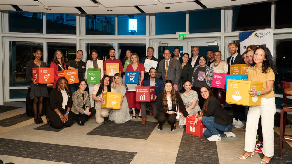 Students, facukty and staff pose with signs representing UN's sustainable development goals.