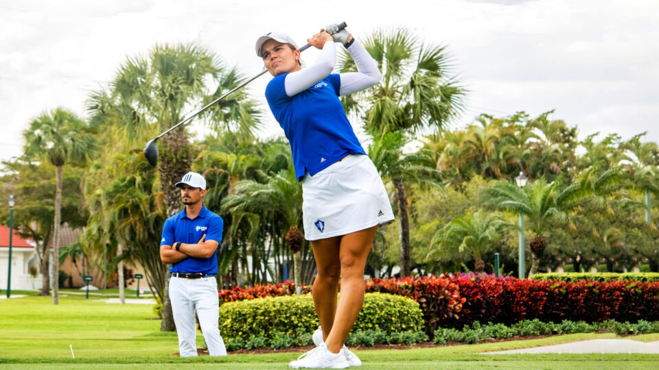 Student-athlete, Helen Kreuzer, takes a swing as Coach Marcelo Huarte looks on.