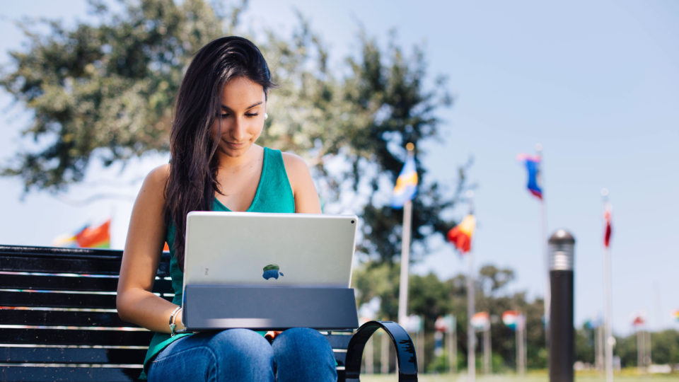 Undergraduate international student, Eloisa Sarmiento, uses her iPad Pro with keyboard outside.